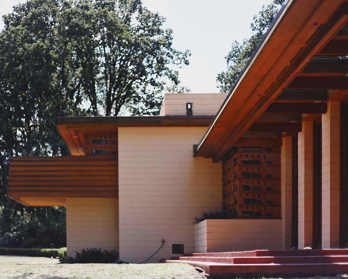 wood white concrete house surrounded with tall and green trees porch